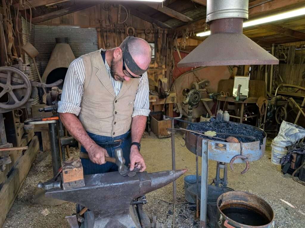 Man forging metal in an antique blacksmith shop