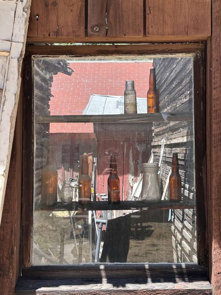 Vintage bottles sitting in a decrepit window