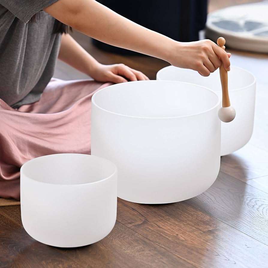 Woman playing crystal sound bowls